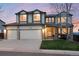 Charming two-story home featuring a three-car garage, a welcoming front porch, and manicured lawn at 10233 Silver Maple Cir, Highlands Ranch, CO 80129