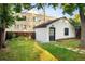 Wide view of a grassy backyard with a carriage house, stone walkway, and partial fencing at 1815 S Ogden St, Denver, CO 80210