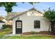 Charming painted brick carriage house with a black door and lush landscaping at 1815 S Ogden St, Denver, CO 80210