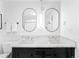 Bright bathroom featuring a double vanity with marble countertop and modern, oval mirrors at 1815 S Ogden St, Denver, CO 80210