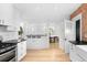 Charming kitchen featuring white cabinets, stainless steel appliances, and exposed brick at 1815 S Ogden St, Denver, CO 80210