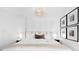 Bright bedroom with white walls, stylish light fixture and decorative pictures at 1815 S Ogden St, Denver, CO 80210