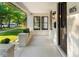 Spacious covered front porch with a concrete floor and classic black door at 1815 S Ogden St, Denver, CO 80210