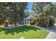 Charming front yard with mature trees, manicured lawn, brick accents, and covered entry at 2773 S Macon St, Aurora, CO 80014