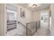 Upstairs hallway with metal railing offering access to a bedroom and bathroom at 2773 S Macon St, Aurora, CO 80014