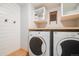 Functional laundry room with modern washer and dryer units and storage at 2773 S Macon St, Aurora, CO 80014