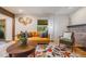 Bright living room featuring a patterned rug, orange sofa, and charming decor at 2773 S Macon St, Aurora, CO 80014