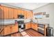 Stylish kitchen featuring wood cabinetry, stainless steel appliances, and subway tile backsplash at 10286 Rotherwood Cir, Highlands Ranch, CO 80130