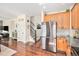 Open-concept view of the stainless steel refrigerator and kitchen appliances near the front door and staircase at 10286 Rotherwood Cir, Highlands Ranch, CO 80130