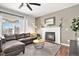 Comfortable living room featuring a fireplace, hardwood floors, and a large sectional sofa at 10286 Rotherwood Cir, Highlands Ranch, CO 80130