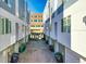 Row of modern townhomes showcasing garage access and contemporary design, with trash bins lined in the entry at 2044 N High St, Denver, CO 80205