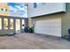 Exterior image of a garage with a white door and a concrete driveway, with recycling and trash containers at 2044 N High St, Denver, CO 80205