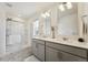 Bathroom featuring dual sinks, framed mirrors, modern vanity, and glass-enclosed shower at 2201 Monte Vista St, Fort Lupton, CO 80621