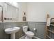 Charming powder room with vintage-style mirror and decorative wall paneling at 2201 Monte Vista St, Fort Lupton, CO 80621