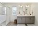 Bathroom featuring dual sinks, framed mirrors, modern vanity, and glass-enclosed shower at 2201 Monte Vista St, Fort Lupton, CO 80621