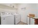 Well-lit laundry room with washer, dryer, shelving, and storage cabinet at 2201 Monte Vista St, Fort Lupton, CO 80621
