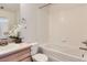 Full bathroom with a shower-tub combo, vanity with updated fixtures, and a white tiled surround at 5957 Turnstone Pl, Castle Rock, CO 80104