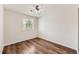 A bright bedroom features hardwood floors, a ceiling fan, and plantation shutters at 5957 Turnstone Pl, Castle Rock, CO 80104