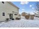 Spacious fenced backyard partially covered in snow with a patio, grill, and outdoor furniture at 18755 Burlington Pl, Denver, CO 80249