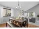 Open dining room with sleek chandelier, wood floors, and a view into a cozy living area with gray couch at 5531 S Telluride Ct, Centennial, CO 80015