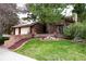 Charming brick home featuring a well-maintained lawn and two-car garage, complete with mature landscaping at 5531 S Telluride Ct, Centennial, CO 80015