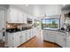 Bright kitchen with white cabinets, granite countertops, and hardwood floors with an open view to the backyard at 5531 S Telluride Ct, Centennial, CO 80015