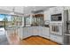 Well-lit kitchen with island, white cabinets, and connection to bright sunroom dining area at 5531 S Telluride Ct, Centennial, CO 80015