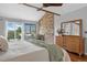 Inviting bedroom boasts a brick accent wall with fireplace, balcony access, and ample natural light at 5531 S Telluride Ct, Centennial, CO 80015