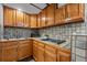 Wet bar with light wood cabinets, tile countertops, stainless steel sink at 5531 S Telluride Ct, Centennial, CO 80015