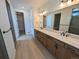 Large bathroom featuring double sinks, contemporary fixtures, and a walk-in closet at 8326 Cokedale Cir, Littleton, CO 80125
