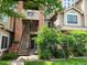 Inviting exterior of a multi-story condo building with well-maintained landscaping and a staircase leading to the entrance at 4760 S Wadsworth # 301, Littleton, CO 80123