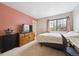 Cozy bedroom with a large window, wood dresser, TV, carpet, and a comfortable bed at 7450 W Coal Mine Ave # D, Littleton, CO 80123