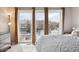 Cozy main bedroom featuring large windows with neighborhood views, a comfortable bed, and plenty of natural light at 7450 W Coal Mine Ave # D, Littleton, CO 80123