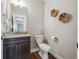 Stylish half-bathroom with a floating vanity, modern fixtures, and wood look floors at 8784 S Riviera Ct, Aurora, CO 80016