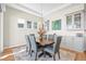 Elegant dining room with a wooden table, comfortable seating, and natural light from the windows at 8784 S Riviera Ct, Aurora, CO 80016