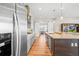 Contemporary kitchen with stainless steel appliances, a large island, and hardwood floors leading to a bright dining area at 8784 S Riviera Ct, Aurora, CO 80016