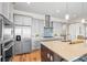 Bright kitchen with stainless steel appliances, gray cabinets, and a large island featuring a sink at 8784 S Riviera Ct, Aurora, CO 80016