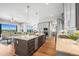 A modern kitchen with an island and stainless steel appliances opens up to the living room at 8784 S Riviera Ct, Aurora, CO 80016