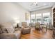 The cozy living room features a sitting area and a dining area with hardwood floors at 8784 S Riviera Ct, Aurora, CO 80016