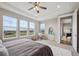 Bright main bedroom boasts three large windows, soft decor, and comfortable seating at 8784 S Riviera Ct, Aurora, CO 80016