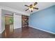 Bedroom boasts unique barn door, modern ceiling fan, and blue accent wall at 3806 S Yosemite St, Denver, CO 80237