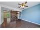 Bedroom boasts unique barn door, custom shelves, modern ceiling fan, and blue accent wall at 3806 S Yosemite St, Denver, CO 80237