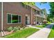 Charming brick townhome with a well-manicured lawn and sidewalk at 3806 S Yosemite St, Denver, CO 80237