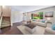 Staged living room with hardwood floors, large windows, and neutral decor at 3806 S Yosemite St, Denver, CO 80237