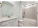 Modern bathroom with a tub, shower, single sink vanity and neutral tiling at 595 Twilight St, Erie, CO 80516