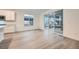 Bright living space with a sliding glass door to the deck, white cabinets and light wood floors at 595 Twilight St, Erie, CO 80516