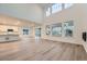 Spacious living room with tall windows, light wood flooring, and an open concept design at 595 Twilight St, Erie, CO 80516