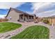 Backyard featuring lush grass, rock landscaping, and an outdoor patio at 15804 Elizabeth Cir, Brighton, CO 80602