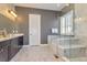 Luxurious bathroom with marble floors, a soaking tub, and a glass-enclosed shower at 15804 Elizabeth Cir, Brighton, CO 80602