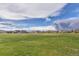 Open field with homes in the background and a cloudy sky at 15804 Elizabeth Cir, Brighton, CO 80602